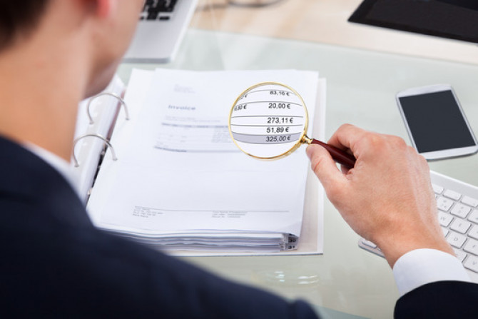 auditor-examining-invoice-with-magnifier-xs.jpg