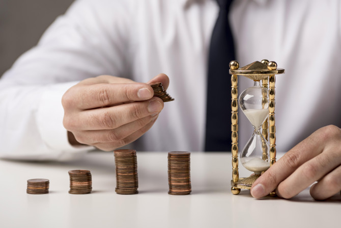 front-view-businessman-with-coins-hourglass.jpg
