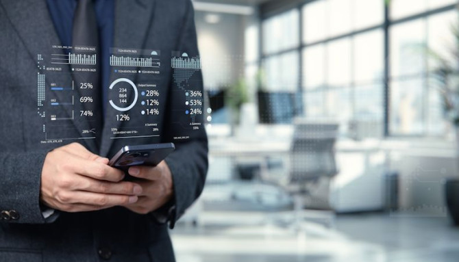 businessman-analyzing-data-with-smartphone-modern-office-setting-with-graphical-interface.jpg