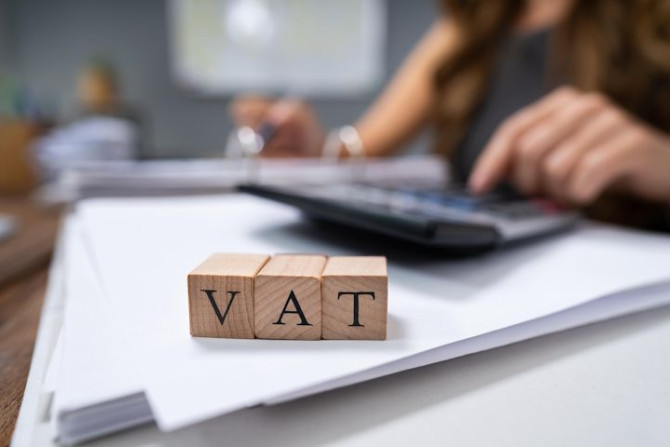 businessperson-s-hand-calculating-vat-with-calculator.jpg