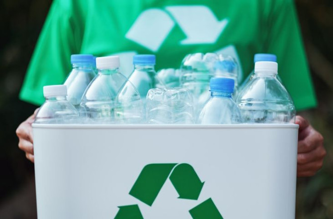 woman-collecting-garbage-holding-recycle-bin-with-plastic-bottles-outdoors.jpg