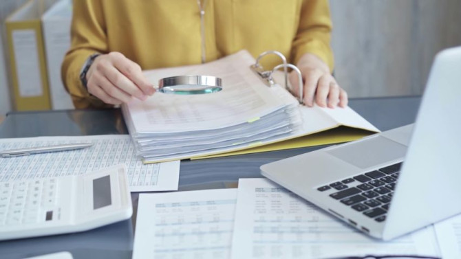 female-auditor-business-attire-inspecting-financial-reports.jpg