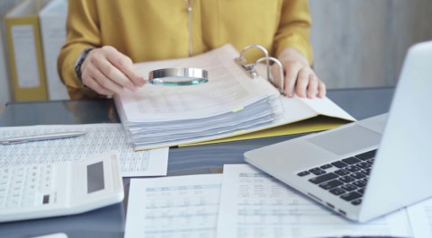 female-auditor-business-attire-inspecting-financial-reports.jpg